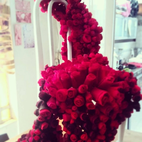 reddish handmade flowers displayed over a chair